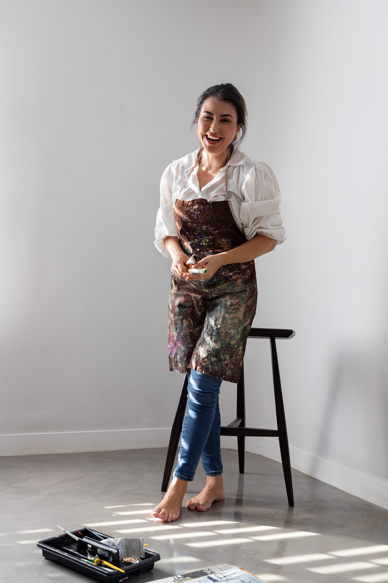 Loris Assis in her studio apron beside a work in progress